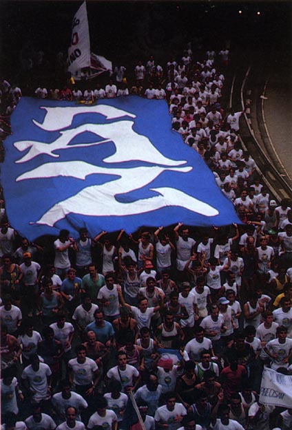 Runners with huge peace banner accompany torch to City Stadium where thousands await. São Paulo, Brazil