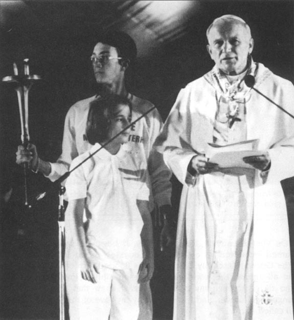 Pope John Paul II honors torch of peace with young runners at gathering of 60,000 at Stade de Gerland. Lyons, France