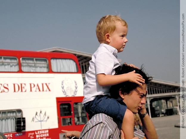 Parisian bus with UN peace symbol and father with child honor flame’s arrival. Paris, France