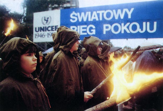 Children standing with makeshift torches in the rain. Warsaw, Poland