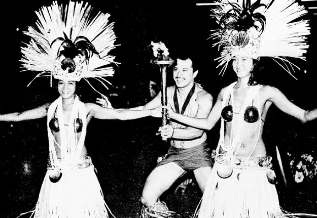 Tahitian dancers in ceremonial dress welcoming torch. Tahiti