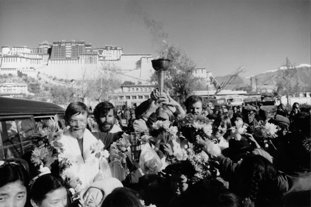 t. Everest torch bearers with backdrop of the Potala, former residence of the Dali Lama. Lhasa, Tibet